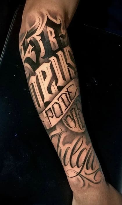 Tatuagem lettering chicano no antebraço com a frase 'Impossível Julgar' em estilo blackwork e sombreado.