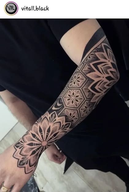 Tatuagem de manga geométrica com pontilhismo e padrões florais em preto e cinza, estilo ornamental.