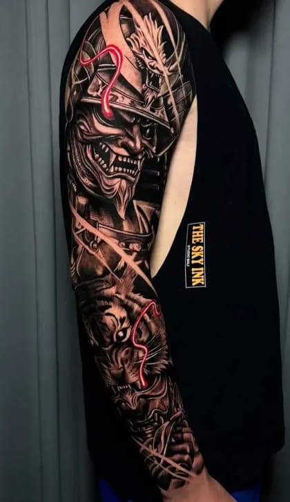 Tatuagem oriental blackwork de braço completo com máscara de samurai, dragão e tigre, detalhes em vermelho neon.