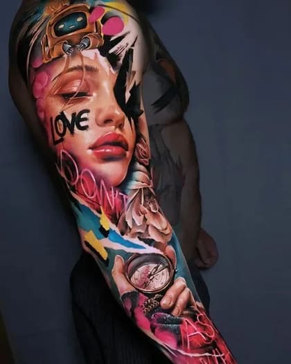 Tatuagem de braço completo em Realismo Colorido com rosto feminino, bússola e elementos abstratos vibrantes.
