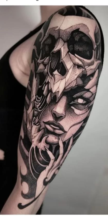 Tatuagem blackwork detalhada de rosto feminino e crânio no braço, com sombreamento em pontilhismo e estilo dark art.